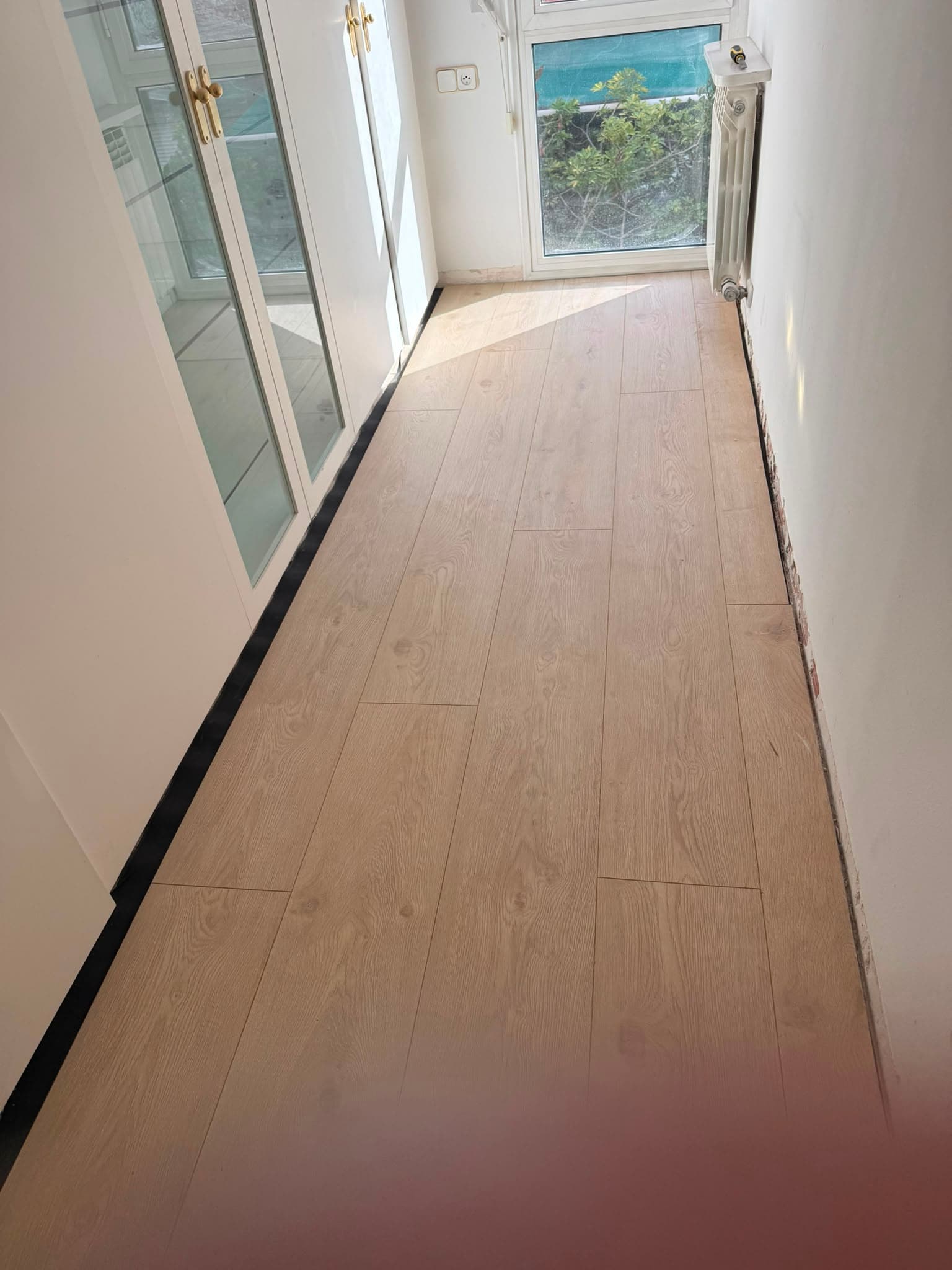 Pasillo con tarima de roble claro instalada por Barcelona Solutions