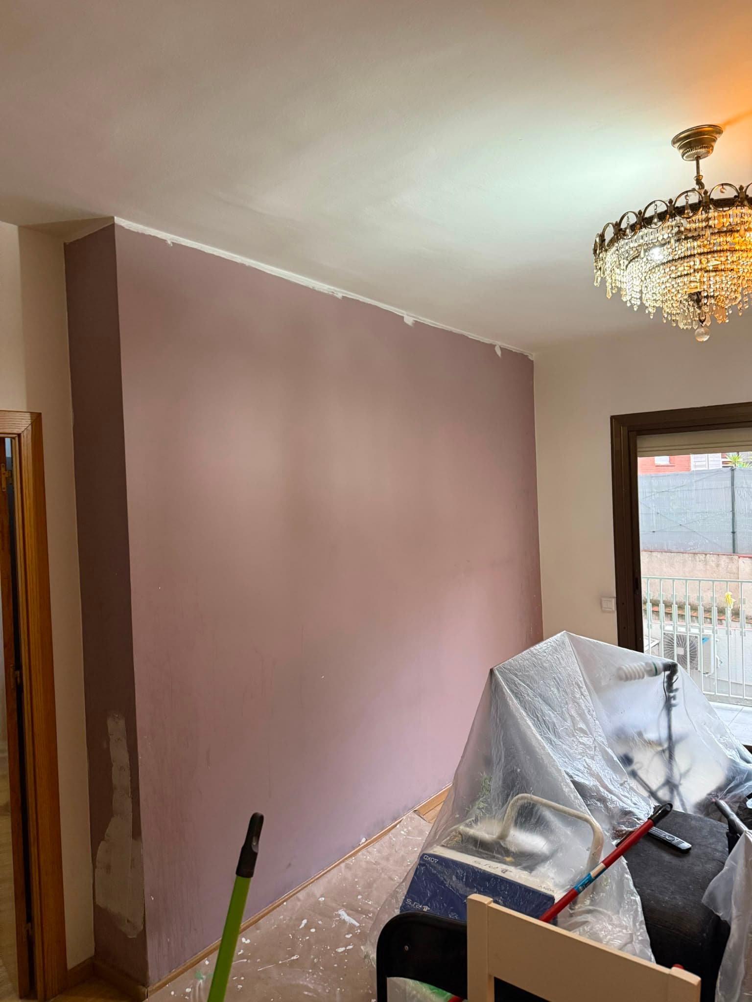 Salón con la pared pintada en malva apagado antes de repintarla