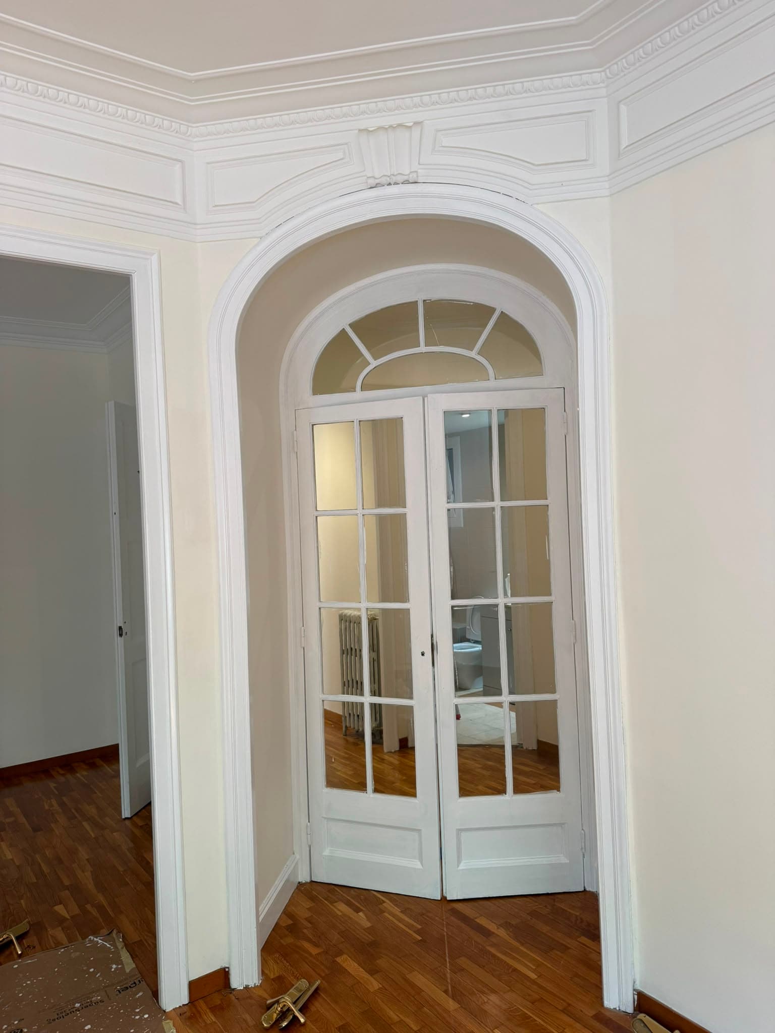 Arco y puertas de un piso clásico lacados en blanco satinado